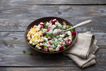 Fresh radish salad with green onions on a wooden background, rustic style