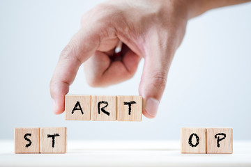 Human hand array Start and stop keyword on wooden cubic. This is wording conceptual create symbol...