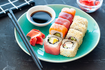Sushi rolls on the plate with soy sauce and chopsticks. Japanese food close up
