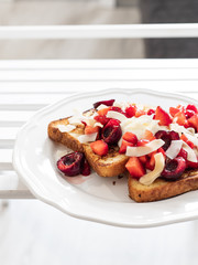 French toast with berries and mascarpone cheese on a light background.
