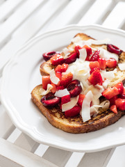 French toast with berries and mascarpone cheese on a light background.