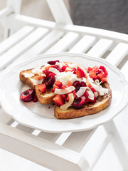 French toast with berries and mascarpone cheese on a light background.
