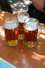 drei Bier im Krug aus Glas im Biergarten