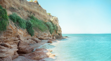 Beautiful sea shore landscape background in light colors. Rocky coast line and crystal blue ocean...