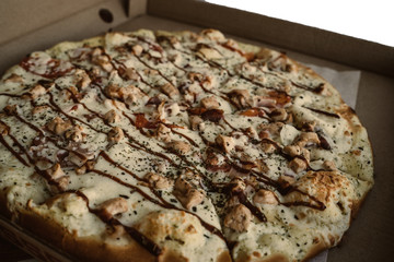 Close-up of pizza, in a cardboard box above the table