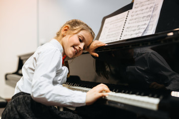 little girl playing piano her professor assistance