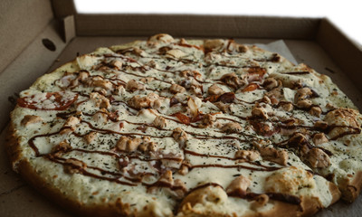 Close-up of pizza, in a cardboard box above the table