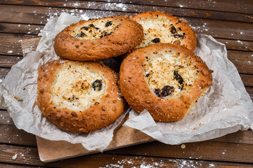 tasty bread on white paper on brown wooden board