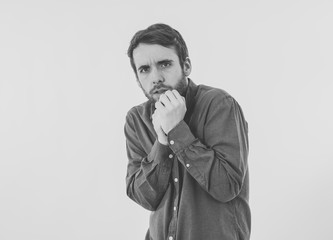 Close up portrait of concern shocked young man with frightened gestures. Scared facial expression