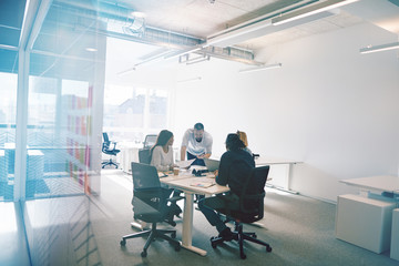 Focused group of colleagues having an office meeting together - obrazy, fototapety, plakaty