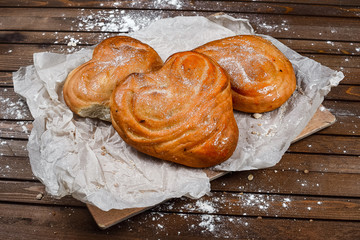 tasty bread on white paper on brown wooden board
