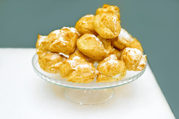 a mountain of fresh eclairs with cream. powdered sugar cake.