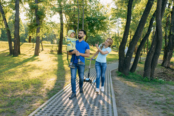 Parents play in the park with their son