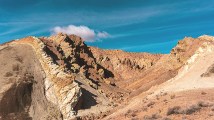 Rainbow Basin Park with its beautifully layered rock formations and cloudy sky. California, USA.