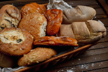 tasty bread on white paper on brown wooden board