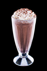 Freshly brewed cappuccino with foam in a glass cup on black isolated background