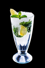 Mojito cocktail with lime, lemon and mint in a glass. Freshness cocktail on black isolated background