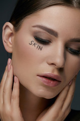 Skin beauty. Woman face with makeup and skin word closeup