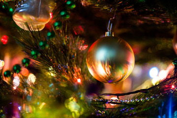 Obraz na płótnie Canvas yellow ball hanging on Christmas tree close-up