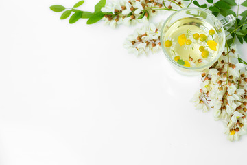 herbal chamomile tea with acacia with  acacia flowers and leaves on a white isolated background. spa concept, chamomile tea