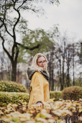 Cute blonde is walking in autumn park
