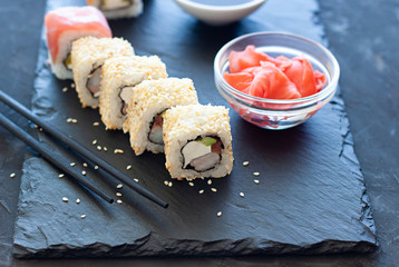 Sushi rolls on the plate with soy sauce and chopsticks. Japanese food close up