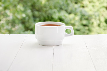 white cup of tea on a white table 