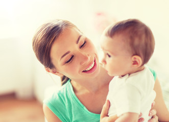 family, child and parenthood concept - happy smiling young mother with little baby at home