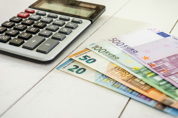 euro banknotes and calculator on white background