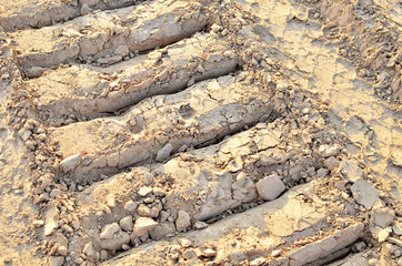 Footprint of a crawler excavator on sand, background, text