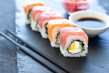 Sushi rolls on the plate with soy sauce and chopsticks. Japanese food close up