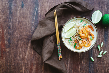Coconut curry soup with noodles and shrimps in bowl. Asian cuisine concept