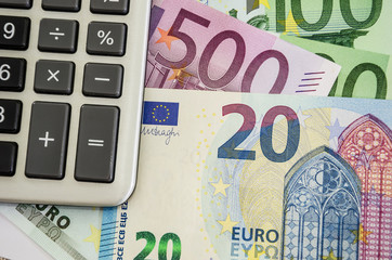 banknotes of 100, 500, 20 euros and a calculator, close-up.