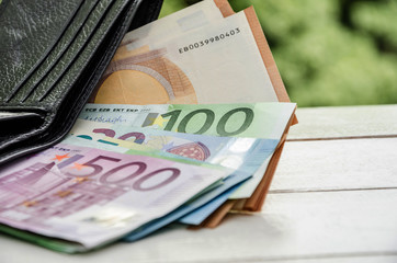 500, 50, 100 Euro banknotes in the wallet on the table. Close-up.