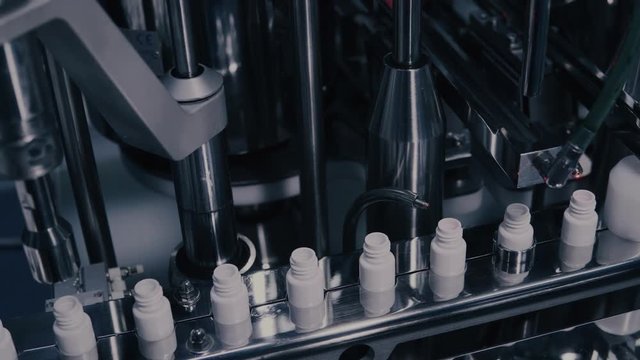 Drug Production. Medical vials on pharmaceutical manufacturing line. Medical ampoules on automated production line at factory. Process of production of pills, tablets. Pharmaceutical industry.