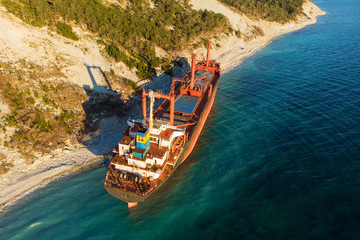 Aerial view of cargo ship run aground on wild coast, shipwreck after storm