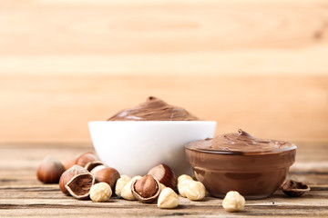 Melted chocolate with hazelnuts on brown wooden table