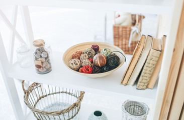 Home details decorations lying on the shelf. Wooden background. Loft style. Cosy rustic mood. Nuts in the jar. Straw basket.