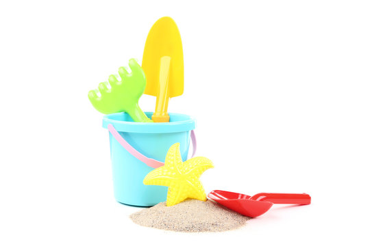 Plastic toys with beach sand isolated on white background