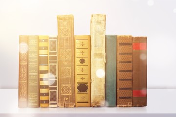 Ancient books in a row on wooden background