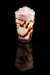 Milk cocktail with ice cream ,summer drink in glass, over black background