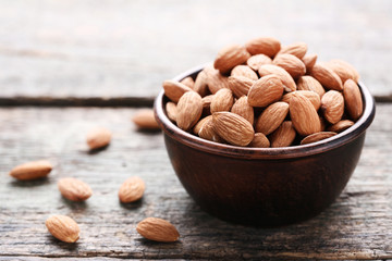 Almonds in bowl on grey wooden table