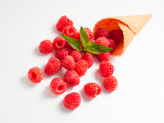 Fresh raspberries with a mint leaf in waffle cone isolated on white background. Closeup view
