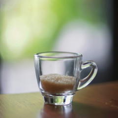 Sugar cane in glass on table with green background