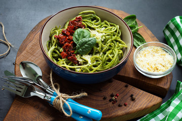 Pasta with spinach creamy sauce, sun dried tomatoes and cheese. Useful tasty homemade food. Selective sharpness, shallow depth of field. Author's retouch