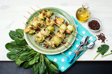 Rolls of zucchini, with chicken and cheese under spices and herbs.  Selective sharpness, shallow depth of field. Author's retouch