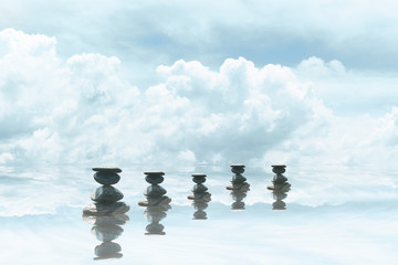 Abstract spirituality of zen stones relaxation on water and blue sky nature background. Natural therapy.