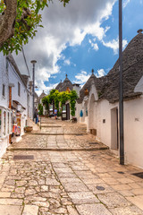 Alberobello in summer sunny day. Original Apulia's town with conic houses. Street view