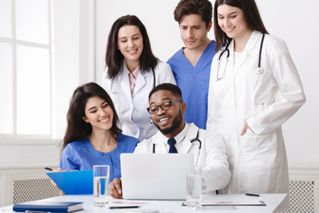 Multinational Group Of Doctors Looking In Laptop