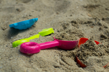 Summer games in the sandbox with colored toys